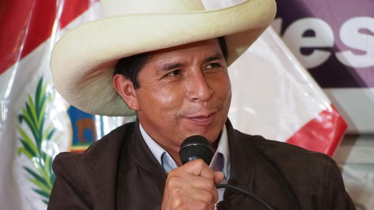 Pedro Castillo, ein dunkelhaariger Mann mit weißem Sombrero, spricht in ein Mikrofon.