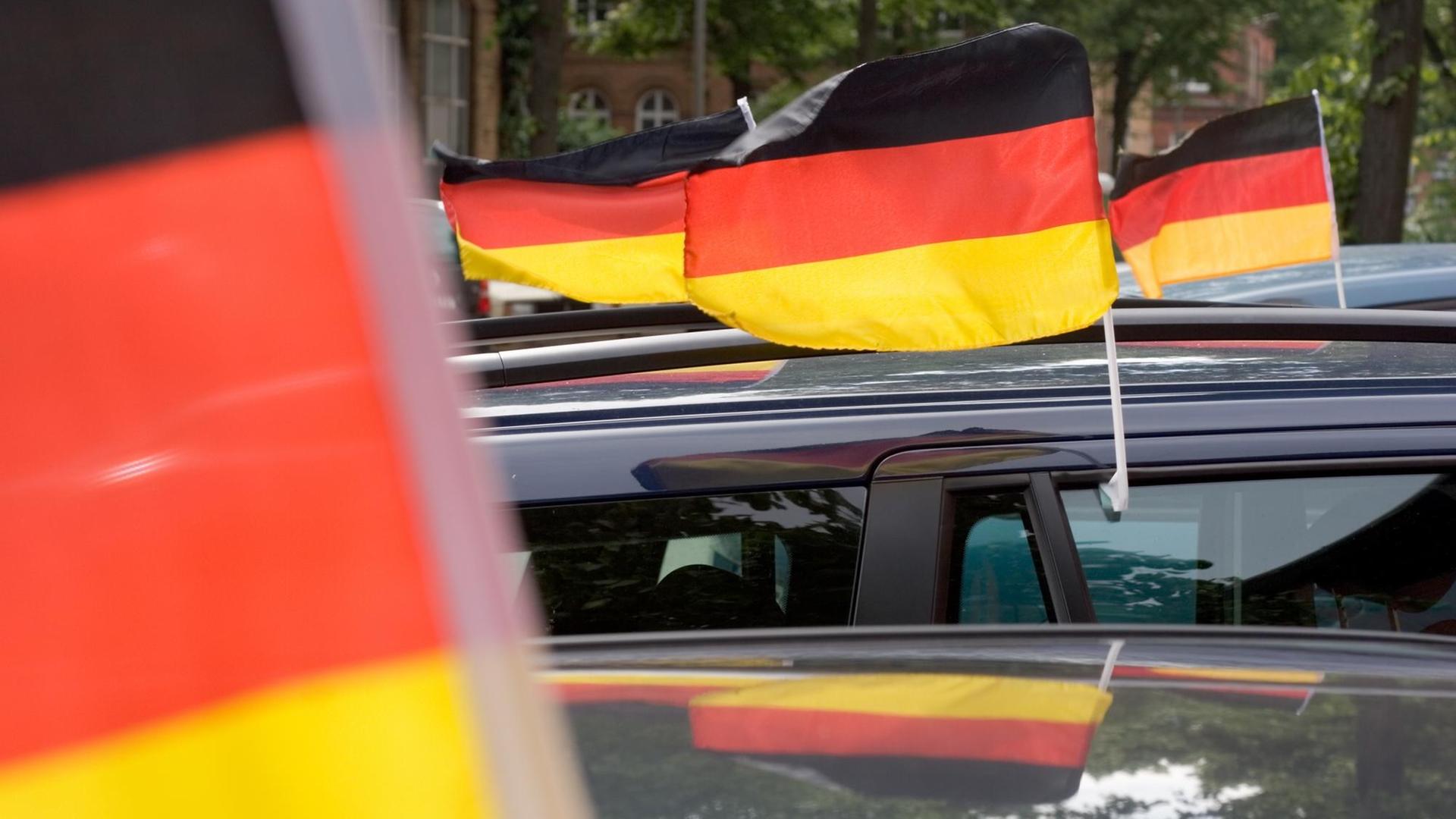 Deutschland-Fahnen wehen an fahrenden Autos. Deutschland-Fahnen wehen an fahrenden Autos.