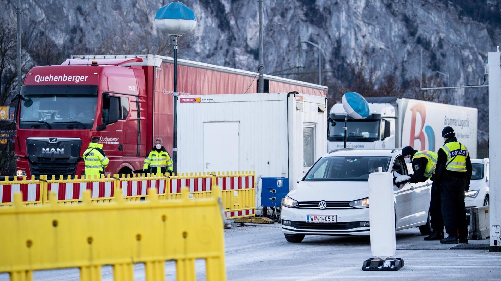 Polizisten kontrollieren Last-Wagen und Autos, die aus Österreich kommen. Polizisten kontrollieren Last-Wagen und Autos, die aus Österreich kommen.