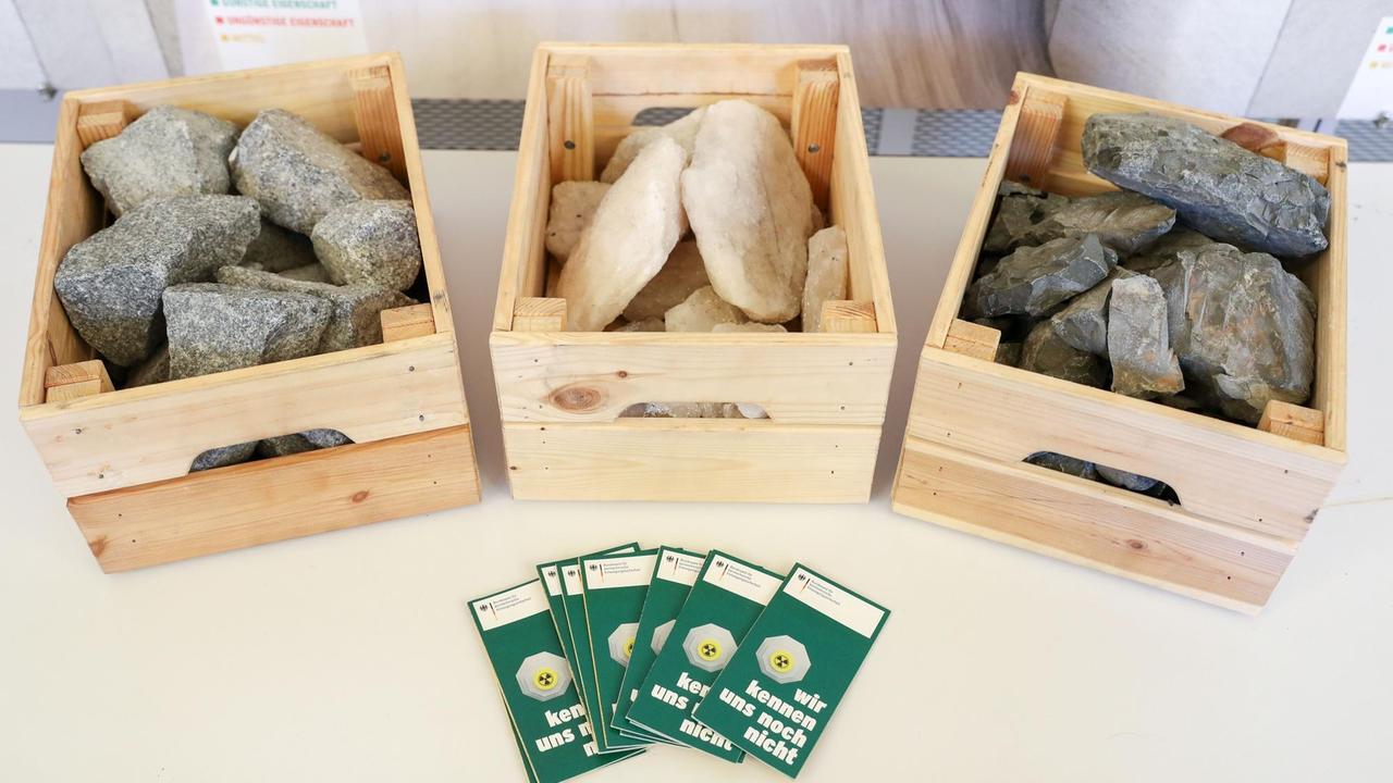 Gesteinsproben von Granit (l-r), aus einem Salzstock und von Tongestein liegen in Holzkisten auf einem Tisch. Gesteinsproben von Granit (l-r), aus einem Salzstock und von Tongestein liegen in Holzkisten auf einem Tisch.