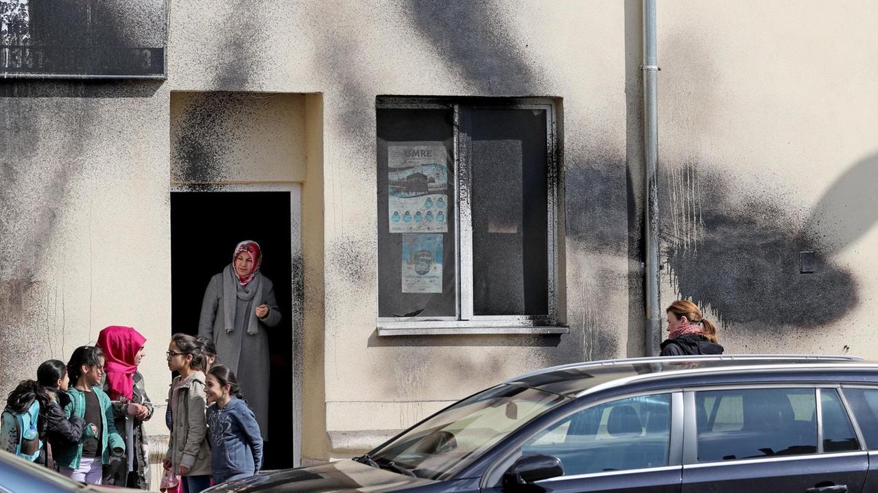 Gemeindemitglieder stehen nach einem Farbanschlag vor einer Moschee in Leipzig. Gemeindemitglieder stehen nach einem Farbanschlag vor einer Moschee in Leipzig.