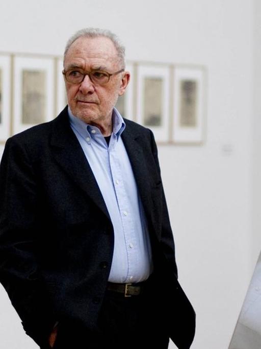 Der Maler Gerhard Richter steht in einer seiner Austellungen. Sein Oberkörper spiegelt sich in einer Glasscheibe.