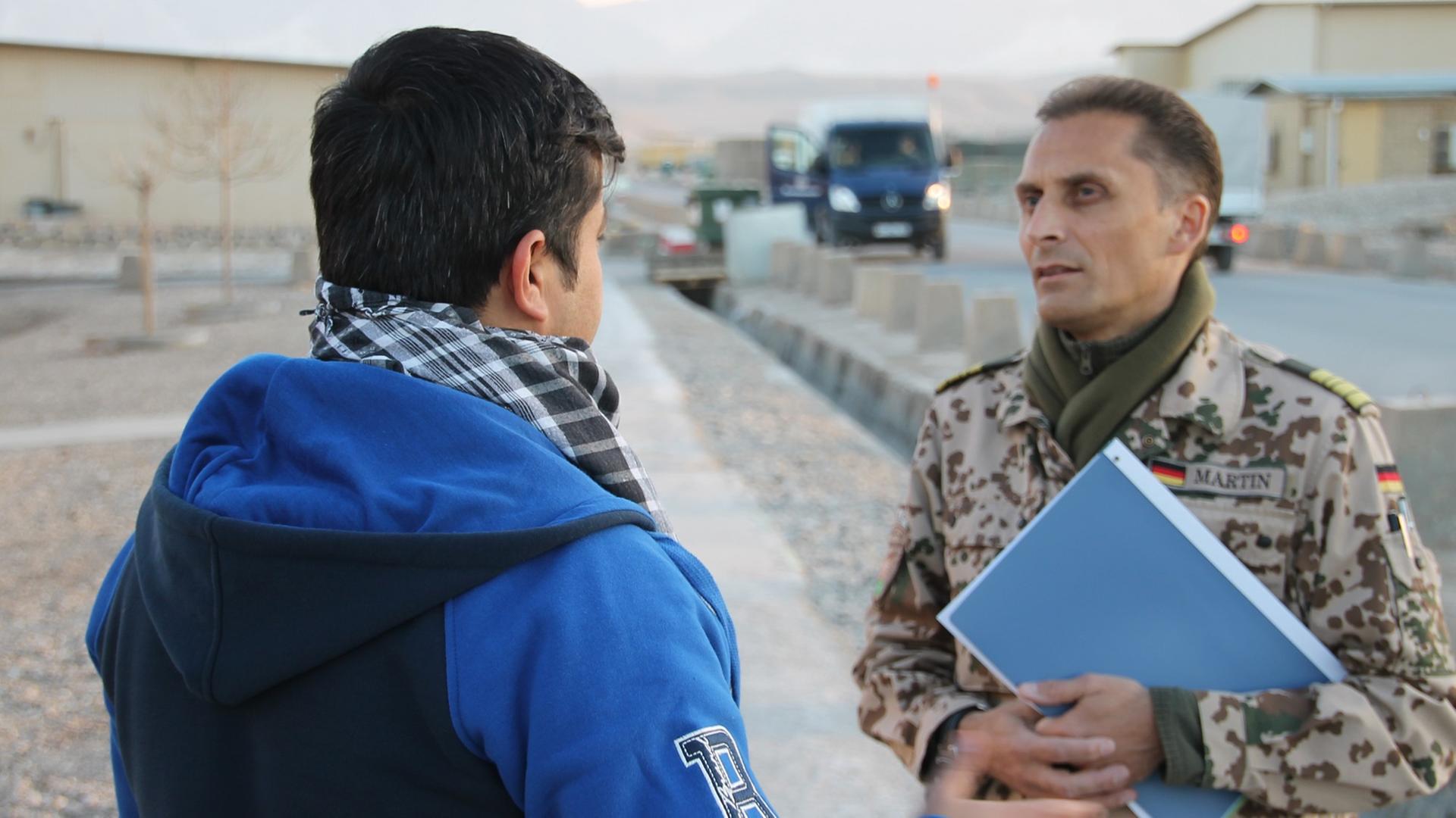 Afghanischer Helfer im Gespräch mit Bundeswehrangehörigem. Afghanischer Helfer im Gespräch mit Bundeswehrangehörigem.