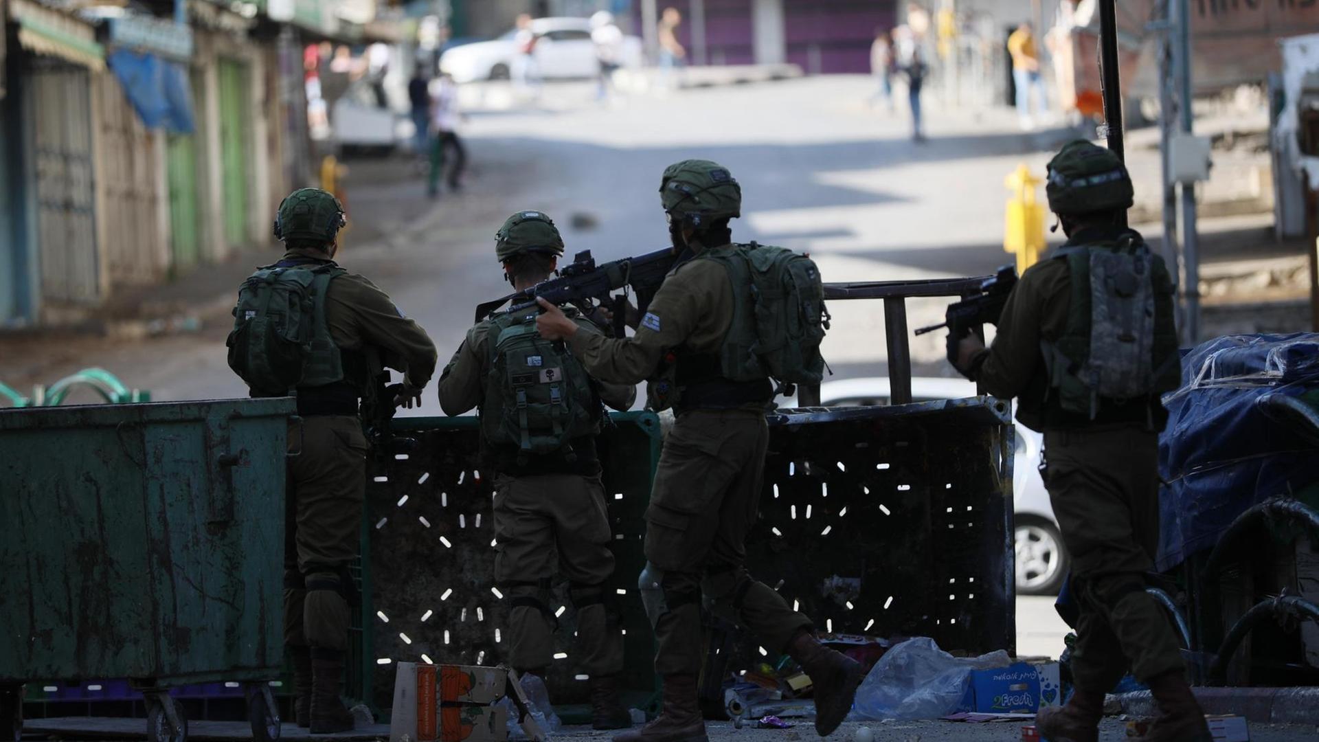 Bewaffnete israelische Sicherheitskräfte stehen in Hebron im Westjordanland hinter eine Absperrung.
