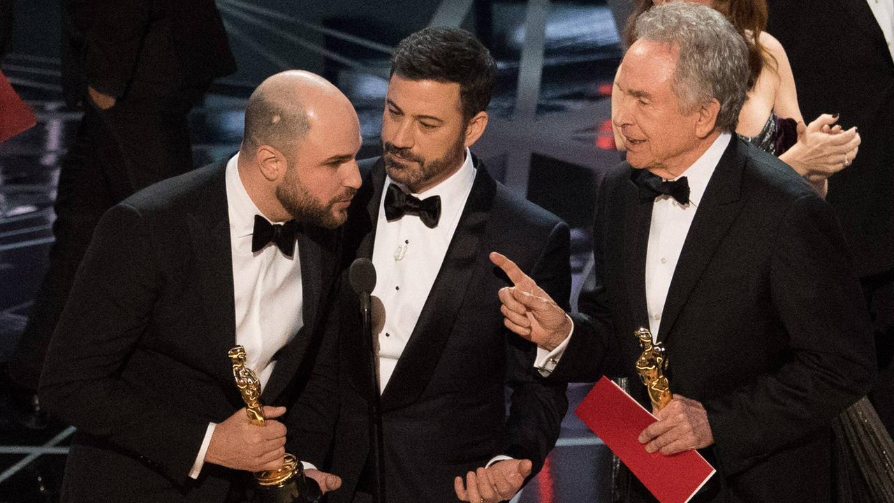 "La La Land"-Produzent Jordan Horowitz, Moderator Jimmy Kimmel und Bester-Film-Laudator Warren Beatty auf der Bühne während einer Panne bei der Verleihung der 89. Oscars. "La La Land"-Produzent Jordan Horowitz hatte irrtümlicherweise wegen einer Umschlag-Verwechselung den Oscar erhalten, der eigentlich Gewinner war dann aber: "Moonlight". "La La Land"-Produzent Jordan Horowitz, Moderator Jimmy Kimmel und Bester-Film-Laudator Warren Beatty auf der Bühne während einer Panne bei der Verleihung der 89. Oscars. "La La Land"-Produzent Jordan Horowitz hatte irrtümlicherweise wegen einer Umschlag-Verwechselung den Oscar erhalten, der eigentlich Gewinner war dann aber: "Moonlight".