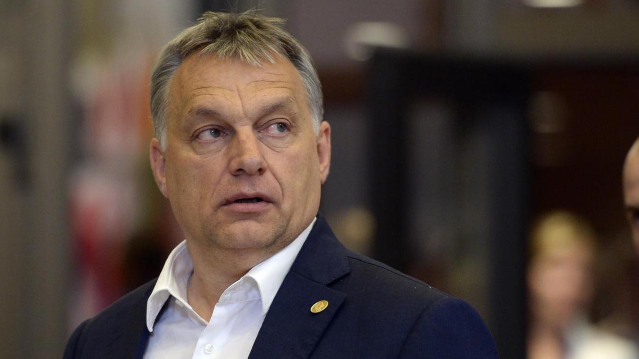 Ungarns Ministerpräsident Viktor Orban blickt im Gehen missgelaunt über die linke Schulter.