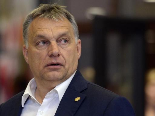 Ungarns Ministerpräsident Viktor Orban blickt im Gehen missgelaunt über die linke Schulter.