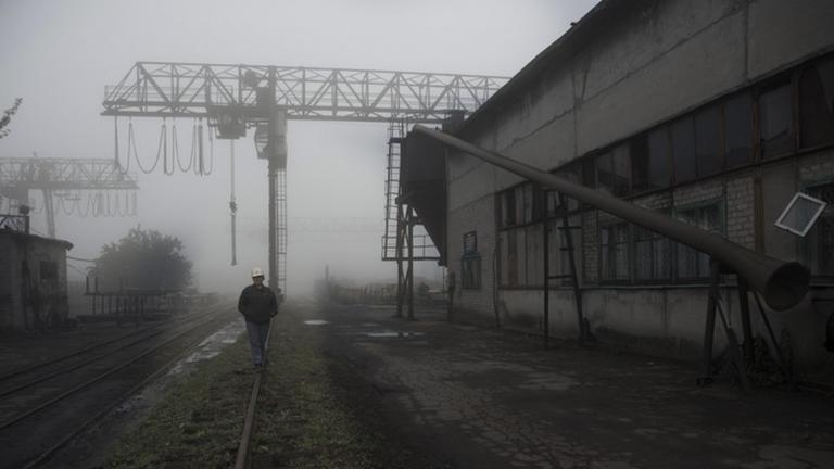Ein Mann läuft durch den Nebel über das Gelände einer ukrainischen Mine.