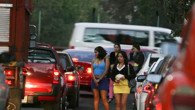 Prostituierte stehen auf einem Straßenstrich zwischen Autos. Prostituierte stehen auf einem Straßenstrich zwischen Autos.