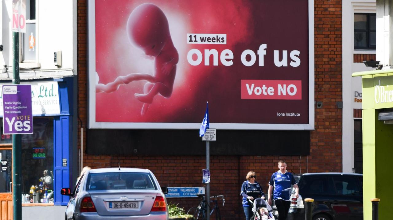 Fußgänger gehen in Dublin, Irland, an Plakatwand vorbei auf der die Abtreibungsgegner für sich werben