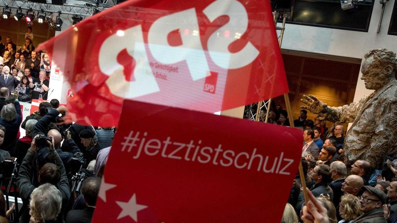 SPD-Anhänger schwenken eine Fahne und halten ein Schild mit der Aufschrift "Jetzt ist Schulz" hoch.