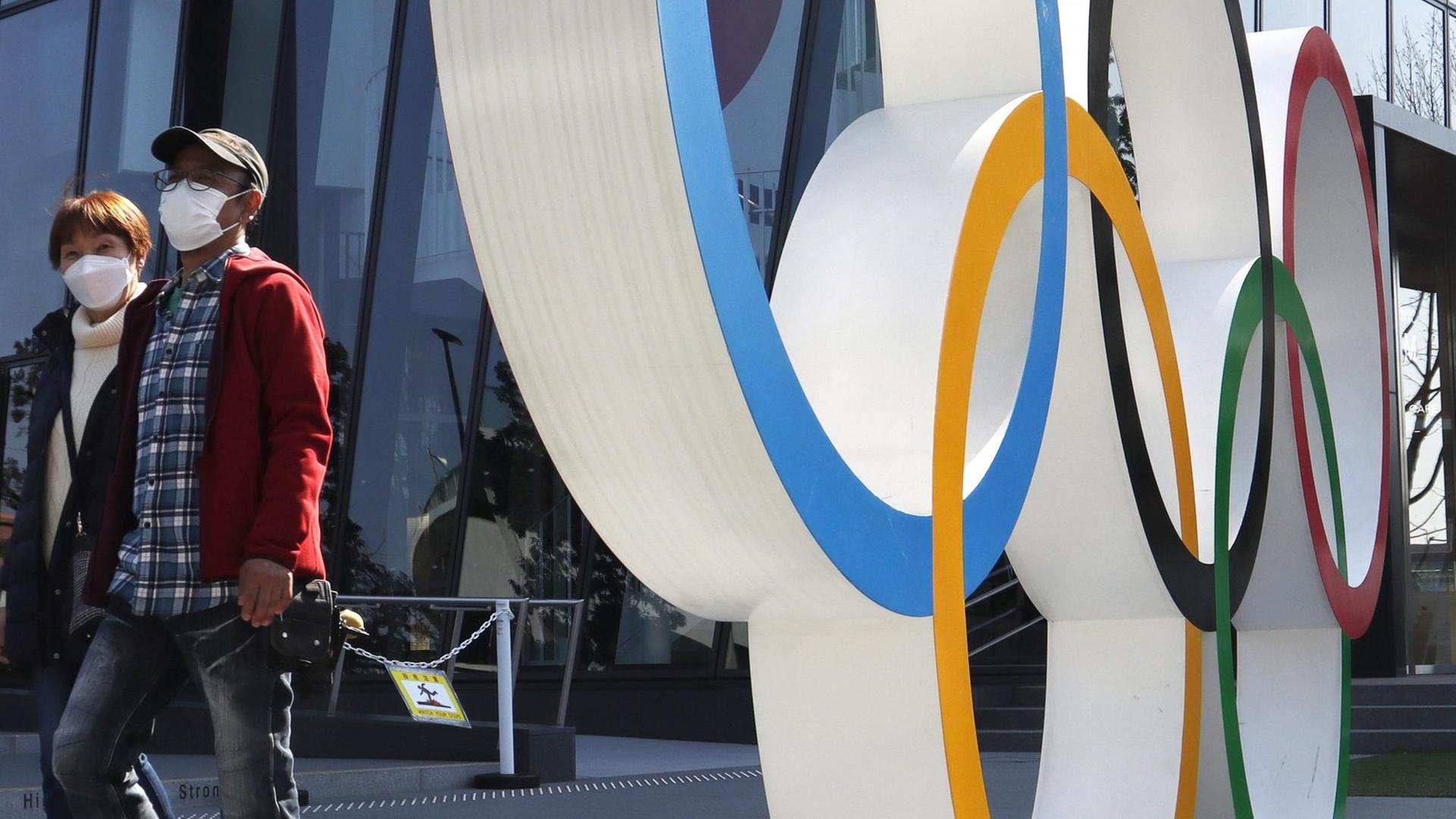 May 4, 2021, Tokyo, Japan: A couple wearing facemasks as a preventive measure against COVID19 is seen next to the Olympic symbols of the five interlaced rings near the National Stadium in Tokyo. Tokyo Japan - ZUMAs197 20210504_zaa_s197_100 Copyright: xJamesxMatsumotox May 4, 2021, Tokyo, Japan: A couple wearing facemasks as a preventive measure against COVID19 is seen next to the Olympic symbols of the five interlaced rings near the National Stadium in Tokyo. Tokyo Japan - ZUMAs197 20210504_zaa_s197_100 Copyright: xJamesxMatsumotox