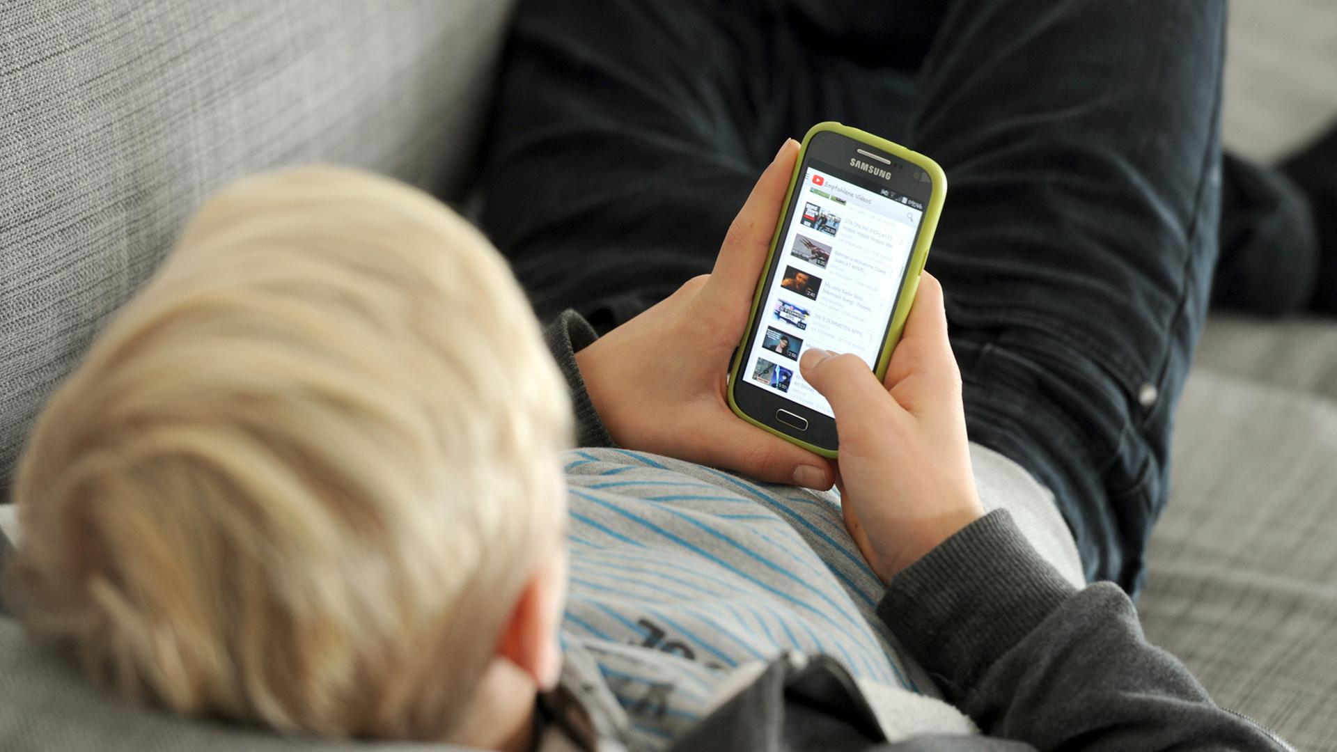 Ein Jugendlicher betrachtet Inhalte auf seinem Smartphone. Ein Jugendlicher betrachtet Inhalte auf seinem Smartphone.