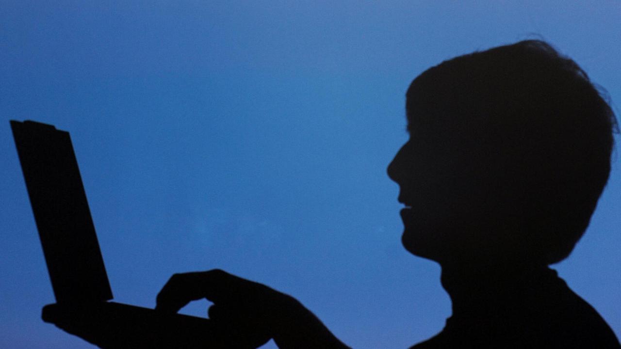 Der Schatten eines Jugendlichen mit einem Laptop Der Schatten eines Jugendlichen mit einem Laptop