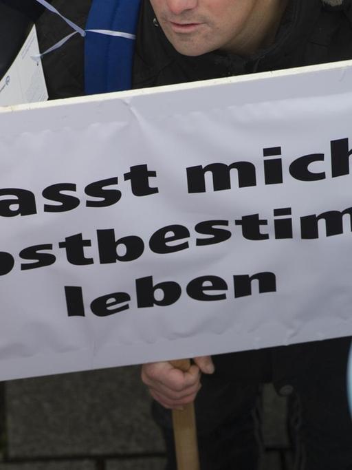 "Lasst mich selbstbestimmt leben" steht am 07.11.2016 in Berlin auf dem Plakat eines Demonstranten vor dem Brandenburger Tor. Die Bundesvereinigung "Lebenshilfe" hatte zu einer Demonstration aufgerufen, um ein besseres Bundesteilhabegesetz (BTHG) für Menschen mit Behinderung zu fordern. Derzeit befassen sich bundespolitische Gremien mit der künftigen Gestaltung des neuen BTHG. Foto: Paul Zinken/dpa ++