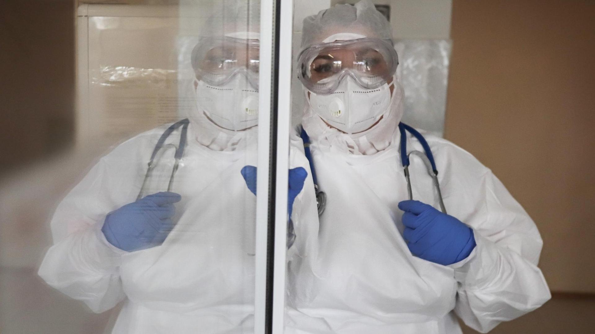 Medizinisches Personal in Schutzanzug und mit Schutzbrille und -maske in einem Krankenhaus in Stavropol Medizinisches Personal in Schutzanzug und mit Schutzbrille und -maske in einem Krankenhaus in Stavropol