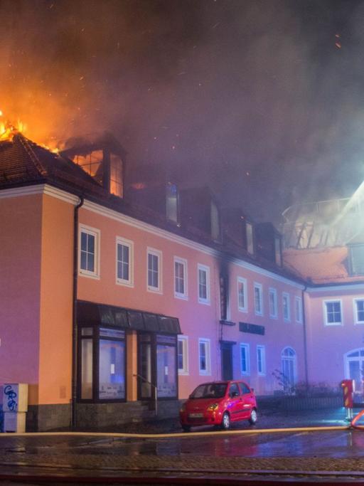 Ein Feuerwehrfahrzeug steht am 21.02.2016 in Bautzen (Sachsen) vor einem brennenden Haus. In einer geplanten Flüchtlingsunterkunft war in der Nacht zu Sonntag ein Feuer ausgebrochen. Foto: Rico Löb/dpa