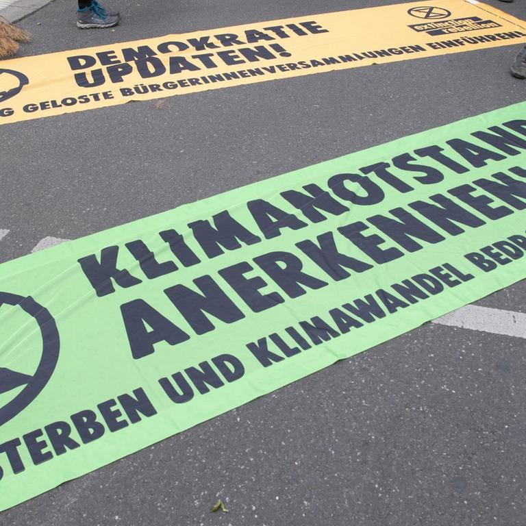 Transparente mit der Aufschrift "Klimanotstand anerkennen" (vorne) und "Demokratie updaten" liegen bei einer Demonstration unter dem Motto "Trauerzug der toten Bäume" von Extinction Rebellion (XR) unweit des Bundeslandwirtschaftsministeriums auf dem Boden.
