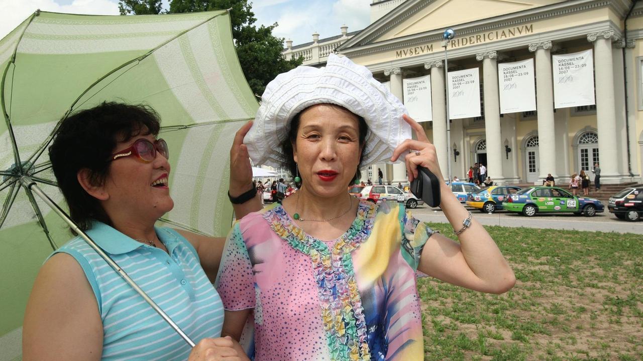 Die beiden Chinesinnen Li Xiurong (l) und Su Changxin vor dem Fridericianum in Kassel. Sie sind Teilnehmer des documenta-Projektes "Fairytales" des chinesischen Künstlers Ai Weiwei. Die beiden Chinesinnen Li Xiurong (l) und Su Changxin vor dem Fridericianum in Kassel. Sie sind Teilnehmer des documenta-Projektes "Fairytales" des chinesischen Künstlers Ai Weiwei.