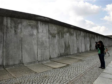 Ein Frau fotografiert ein Mauerteilstück an der Mauer-Gedenkstätte in der Bernauer Straße in Berlin.
