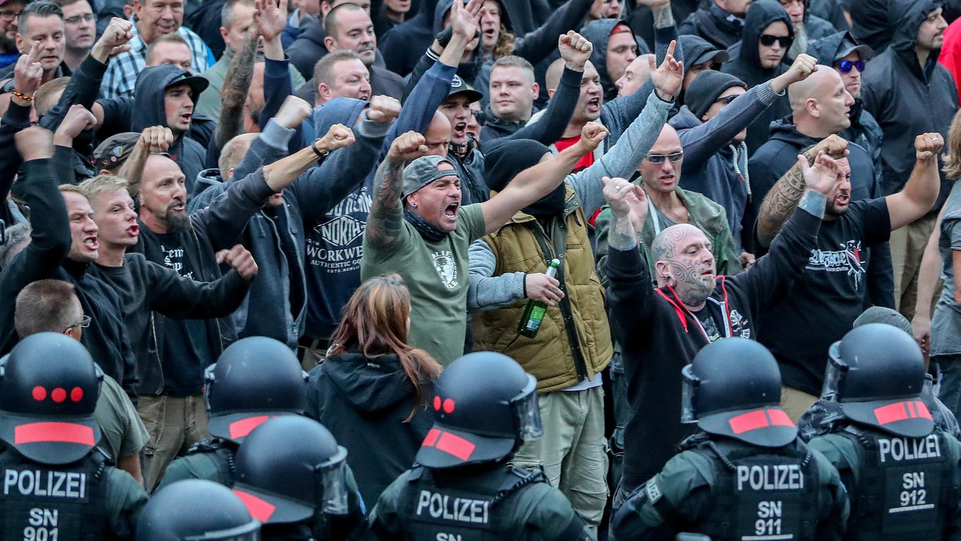 In Chemnitz gestikulieren am 27.8.2018 Demonstranten der rechten Szene und drohen den Gegendemonstranten Gewalt an. In Chemnitz gestikulieren am 27.8.2018 Demonstranten der rechten Szene und drohen den Gegendemonstranten Gewalt an.