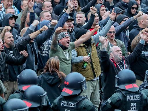 In Chemnitz gestikulieren am 27.8.2018 Demonstranten der rechten Szene und drohen den Gegendemonstranten Gewalt an.