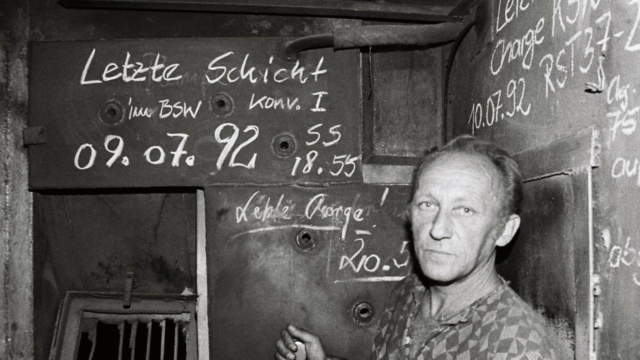 Ein Arbeiter blickt besorgt in die Kamera. Die schwarz-weiße Aufnahme ist entstanden im Stahl- und Walzwerk Maxhütte in Unterwellenborn, Thüringen, nach der letzten Schicht im Juli 1992. Ein Arbeiter blickt besorgt in die Kamera. Die schwarz-weiße Aufnahme ist entstanden im Stahl- und Walzwerk Maxhütte in Unterwellenborn, Thüringen, nach der letzten Schicht im Juli 1992.