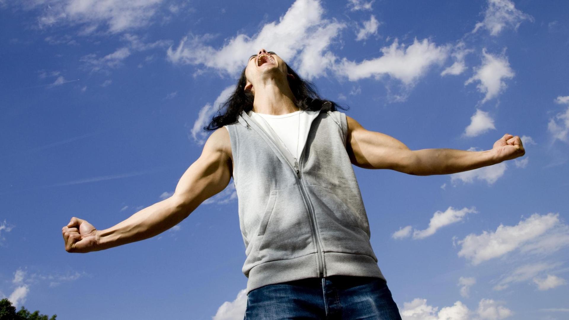 Ein Mann mit ausgebreiteten Armen und angespannten Muskeln schreit aus Leibeskräften gen Himmel. Ein Mann mit ausgebreiteten Armen und angespannten Muskeln schreit aus Leibeskräften gen Himmel.