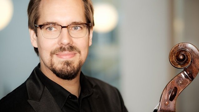 Neben dem Gesicht des Cellisten ist die Schnecke seines Cellos zu sehen. Neben dem Gesicht des Cellisten ist die Schnecke seines Cellos zu sehen.