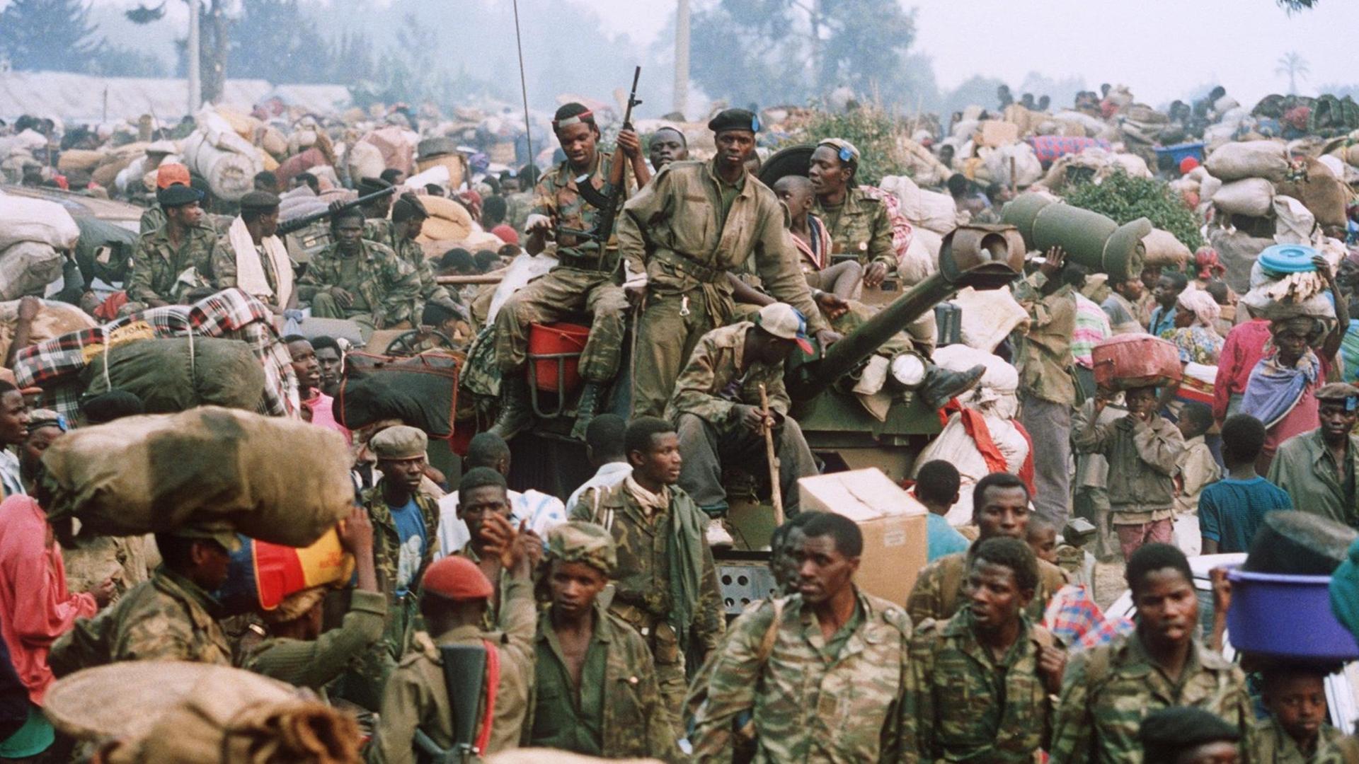 Zusammen mit tausenden von Flüchtlingen erreichen am 17.7.1994 auch Militärs des gestürzten Regimes (M) die Grenzstadt Goma in Zaire. Unter ihnen sind auch Milizen der Hutu-Extremisten, die für den Völkermord verantwortlich gemacht werden. Fast eine halbe Million Ruander flohen ins benachbarte Ausland.