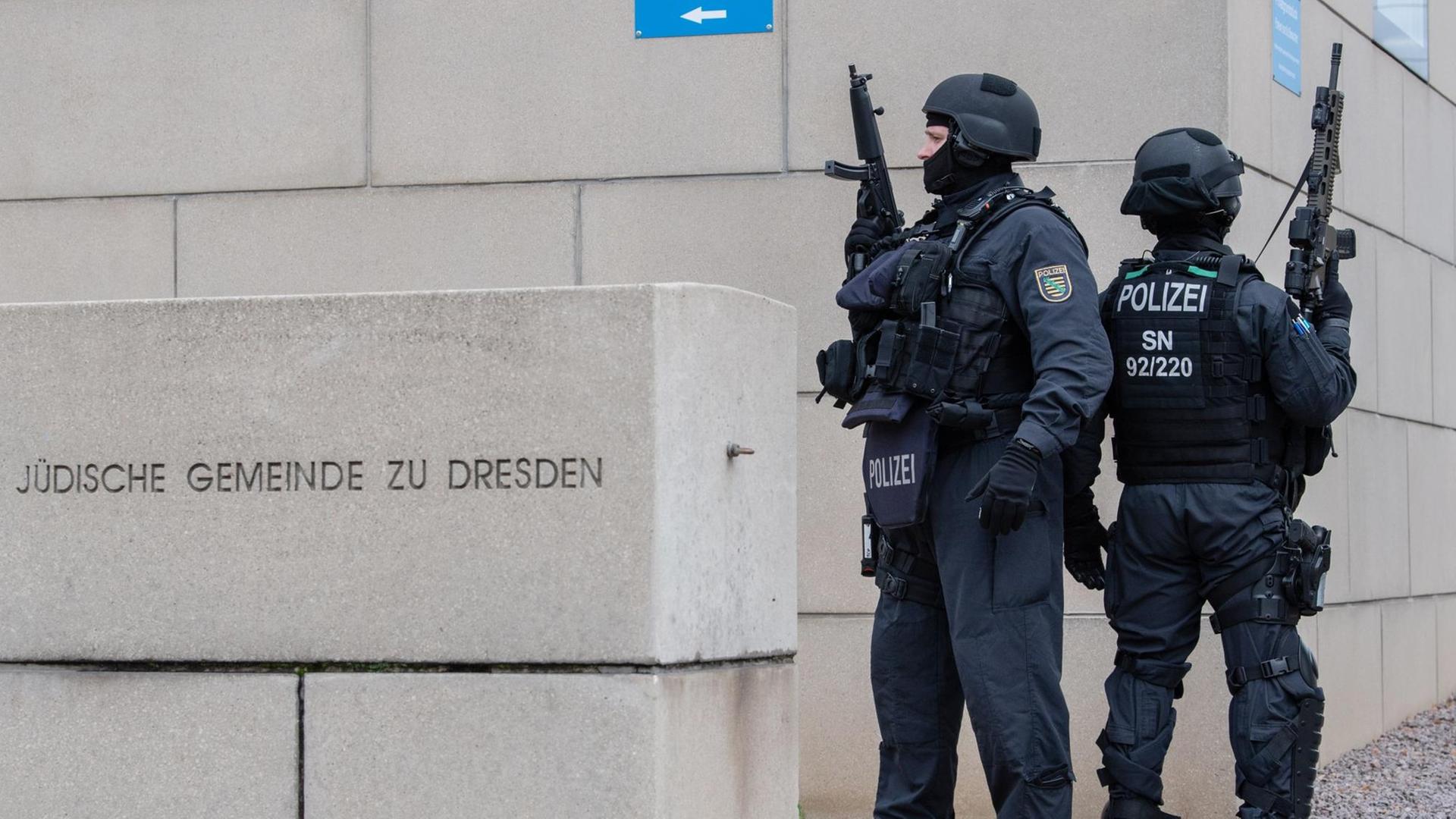 Zwei stark bewaffnete Polizisten stehen vor der Jüdischen Gemeinde zu Dresden. Zwei stark bewaffnete Polizisten stehen vor der Jüdischen Gemeinde zu Dresden.