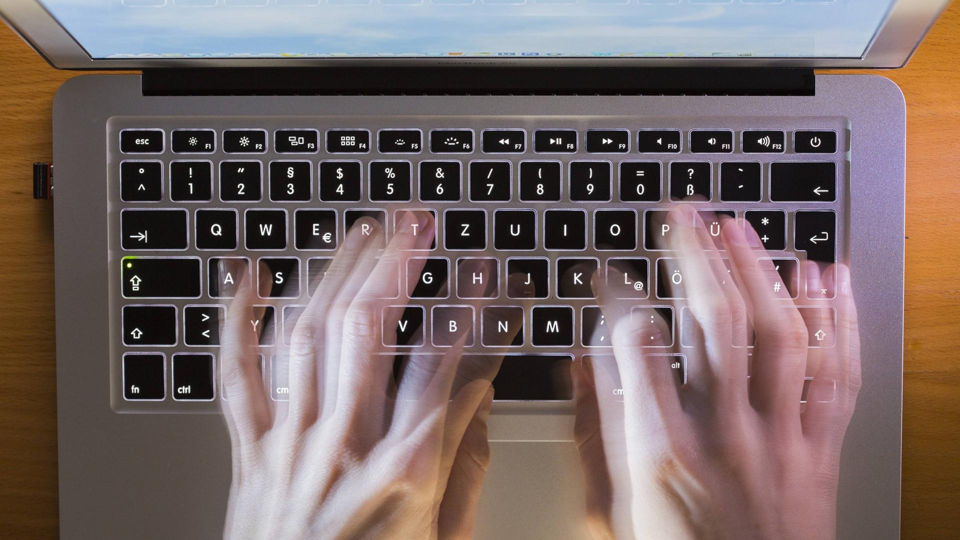 Eine Person tippt auf der Tastatur eines Laptop Computers. Eine Person tippt auf der Tastatur eines Laptop Computers.