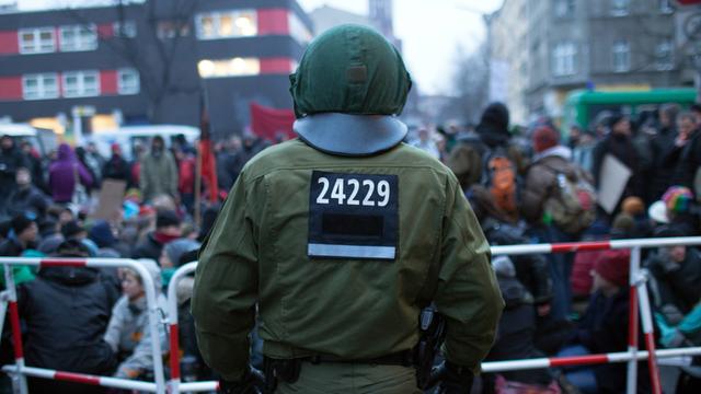 Menschen demonstrieren im Februar 2013 gegen eine Zwangsräumung in Berlin-Kreuzberg: Der Polizist vor der Absperrung trägt zur individuellen Kennzeichnung einen fünfstelligen Zahlencode auf der Uniformjacke.