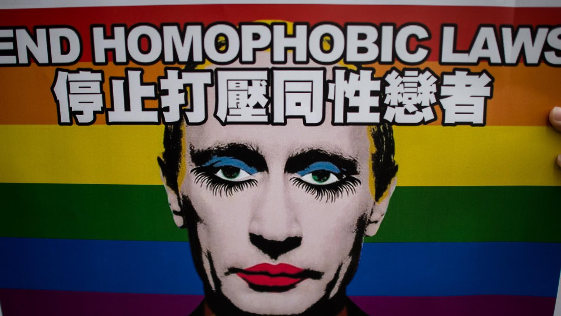 Ein Plakat mit der Aufschrift "End homophobic laws" zeigt einen wie eine Dragqueen geschminkten Wladimir Putin, im Hintergrund die Regenbogenflagge als Symbol der homosexuellen Bewegung. Ein Plakat mit der Aufschrift "End homophobic laws" zeigt einen wie eine Dragqueen geschminkten Wladimir Putin, im Hintergrund die Regenbogenflagge als Symbol der homosexuellen Bewegung.