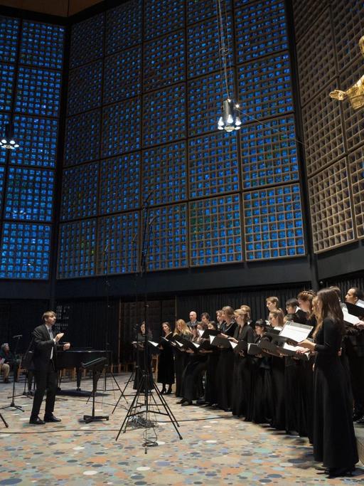 Der Chor steht unter den blauen Fensterkacheln der Kaiser-Wilhelm-Gedächtniskirche Berlin.