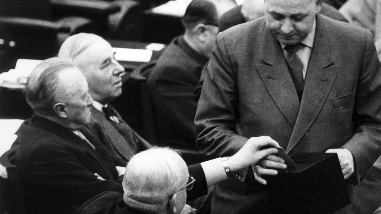 Bundeskanzler Konrad Adenauer (l) und neben ihm der CDU-Abgeordnete Robert Pferdmenges während der Stimmabgabe. Am 26.03.1958 stimmte der Bundestag in Bonn nach einer mehrtägigen und mit Leidenschaft geführten Debatte in der Nacht zum 26.03.1958 der Ausrüstung der Bundeswehr mit taktischen Atomwaffen grundsätzlich für den Fall zu, dass die strategische Planung der NATO diese Ausrüstung fordert und eine allgemeine, kontrollierte Abrüstung nicht zustande kommt. Foto: Kurt Rohwedder +++(c) dpa - Report+++ | Verwendung weltweit