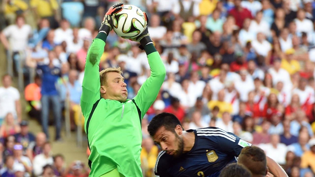 Manuel Neuer springt mit angestrengter Miene in die Luft und fängt einen Ball im Finale der WM gegen Argentinien. Manuel Neuer springt mit angestrengter Miene in die Luft und fängt einen Ball im Finale der WM gegen Argentinien.