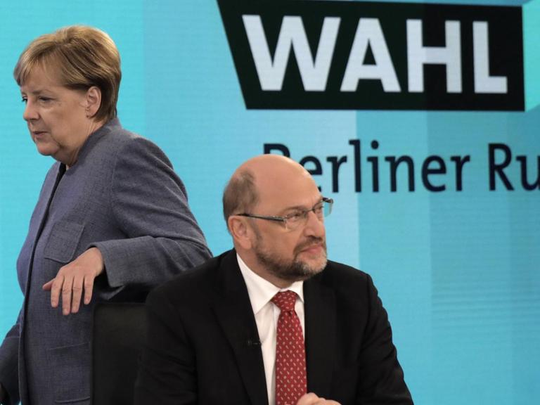 Bundeskanzlerin Angela Merkel (CDU) geht hinter dem SPD-Vorsitzenden Martin Schulz am 24.09.2017 in Berlin vor einer Fernsehrunde der Parteivorsitzenden nach der Bundestagswahl vorbei. 