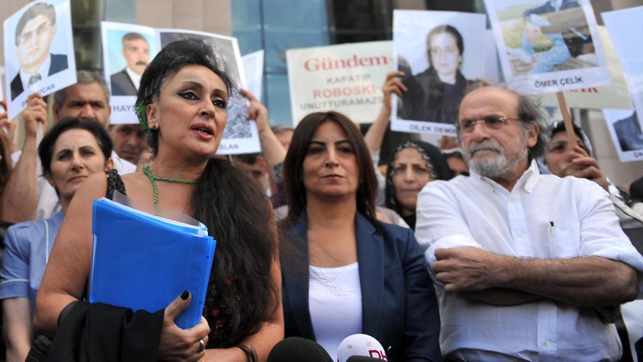 Eren Keskin, die frühere Chefredakteurin der türkischen Zeitung "Özgür Gündem" spricht in Istanbul mit Pressevertretern, während kurdische Frauen Fotos inhaftierter Journalisten zeigen. Eren Keskin, die frühere Chefredakteurin der türkischen Zeitung "Özgür Gündem" spricht in Istanbul mit Pressevertretern, während kurdische Frauen Fotos inhaftierter Journalisten zeigen.