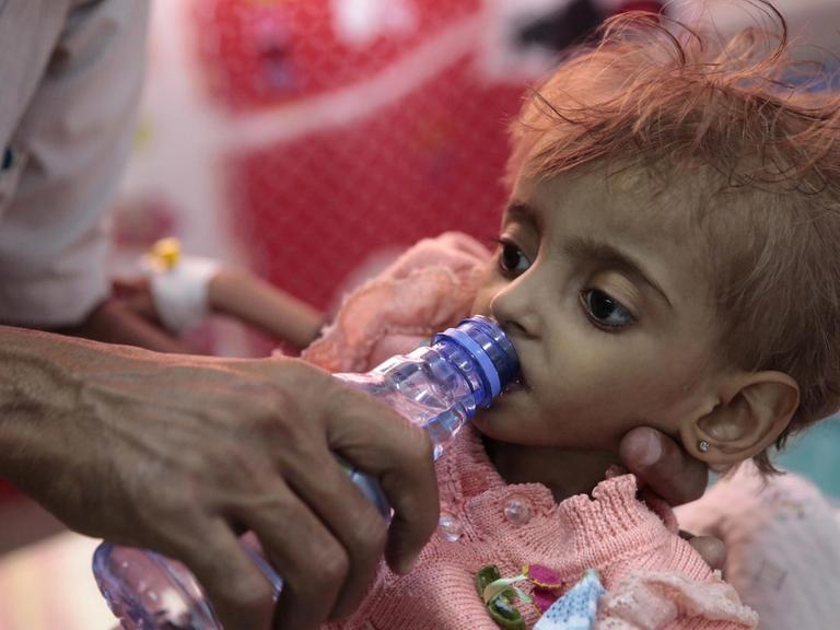 Ein Vater gibt seiner Tochter Wasser zu trinken in einem Hospital in Hodeida
