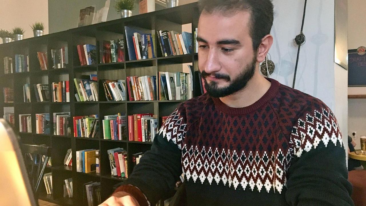Anas Denno sitzt am Computer in einem Wohnzimmer Anas Denno sitzt am Computer in einem Wohnzimmer