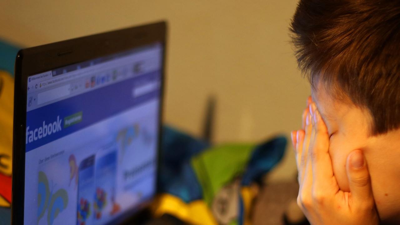 Ein Junge reibt sich am 15.05.2013 vor seinem Laptop beim betrachten der Facebook-Seite die Augen. Ein Junge reibt sich am 15.05.2013 vor seinem Laptop beim betrachten der Facebook-Seite die Augen.