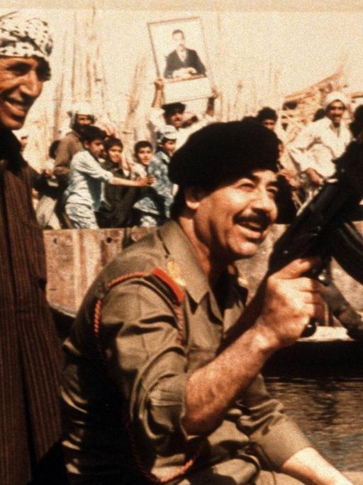 Saddam Hussein (r.), irakischer Diktator in einer Kampfpose vor dem Golf-Krieg 1990