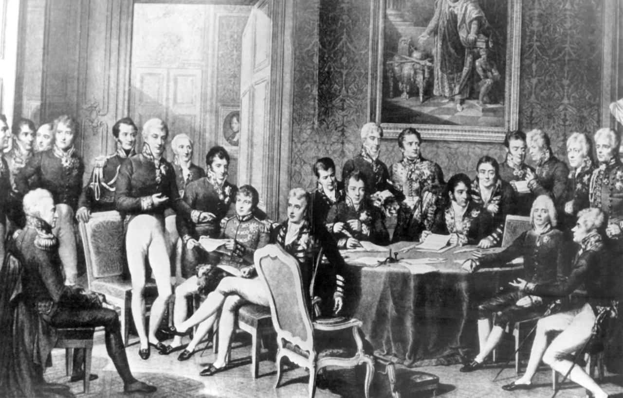 Der Wiener Kongreß (18. September 1814 bis 9. Juni 1815) unter Vorsitz von Klemens Wenzel Fürst von Metternich (stehend 6.v.l.) Der österreichische Staatsmann versuchte durch Kongreßdiplomatie, die vorrevolutionäre politische und soziale Ordnung in Europa wiederherzustellen.
