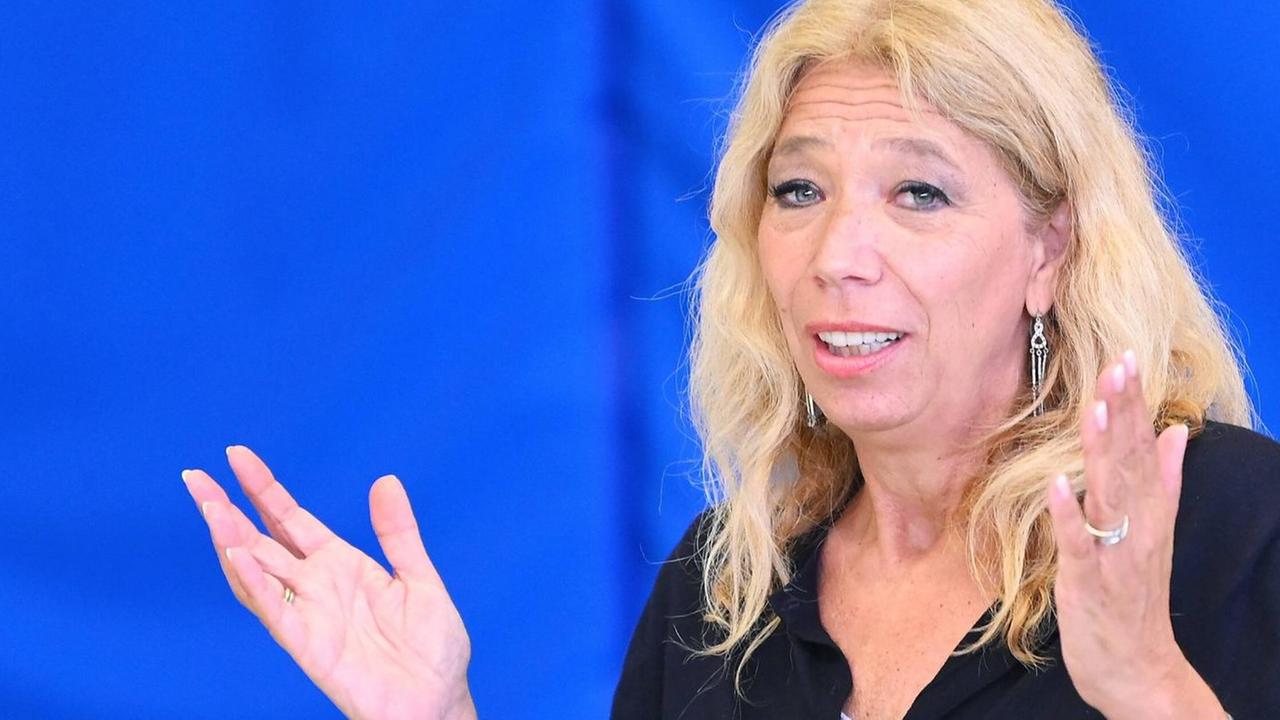 Eine Frau sitzt vor einem Mikrofon und erklärt etwas. Sie trägt ein schwarzes Oberteil. Es ist die Ärztin Lisa Federle. Eine Frau sitzt vor einem Mikrofon und erklärt etwas. Sie trägt ein schwarzes Oberteil. Es ist die Ärztin Lisa Federle.