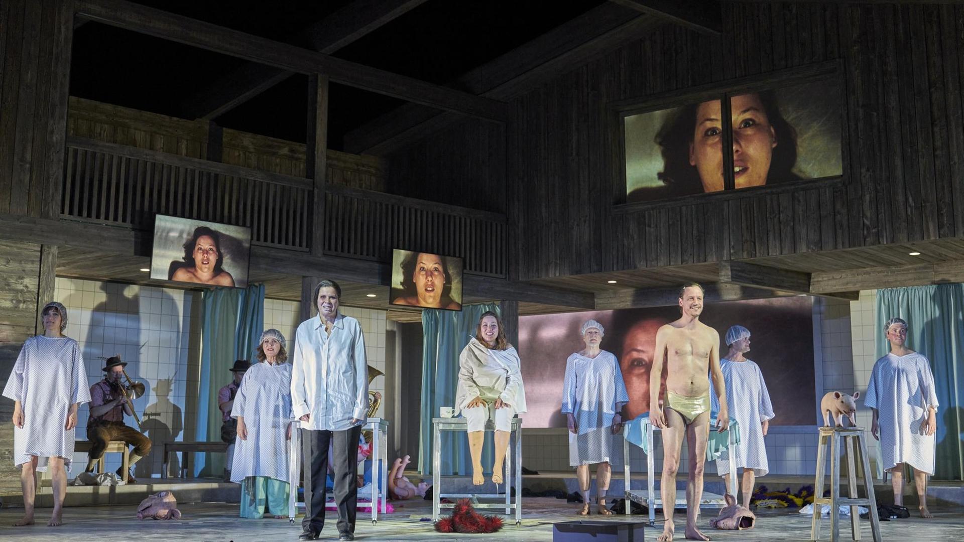 Szene aus dem Stück „Lärm. Blindes Sehen. Blinde sehen!“ am Schauspielhaus Hamburg. Eine Menschengruppe steht in OP-Kleidung auf der Bühne. Szene aus dem Stück „Lärm. Blindes Sehen. Blinde sehen!“ am Schauspielhaus Hamburg. Eine Menschengruppe steht in OP-Kleidung auf der Bühne.