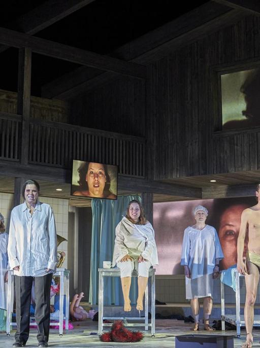 Szene aus dem Stück „Lärm. Blindes Sehen. Blinde sehen!“ am Schauspielhaus Hamburg. Eine Menschengruppe steht in OP-Kleidung auf der Bühne.