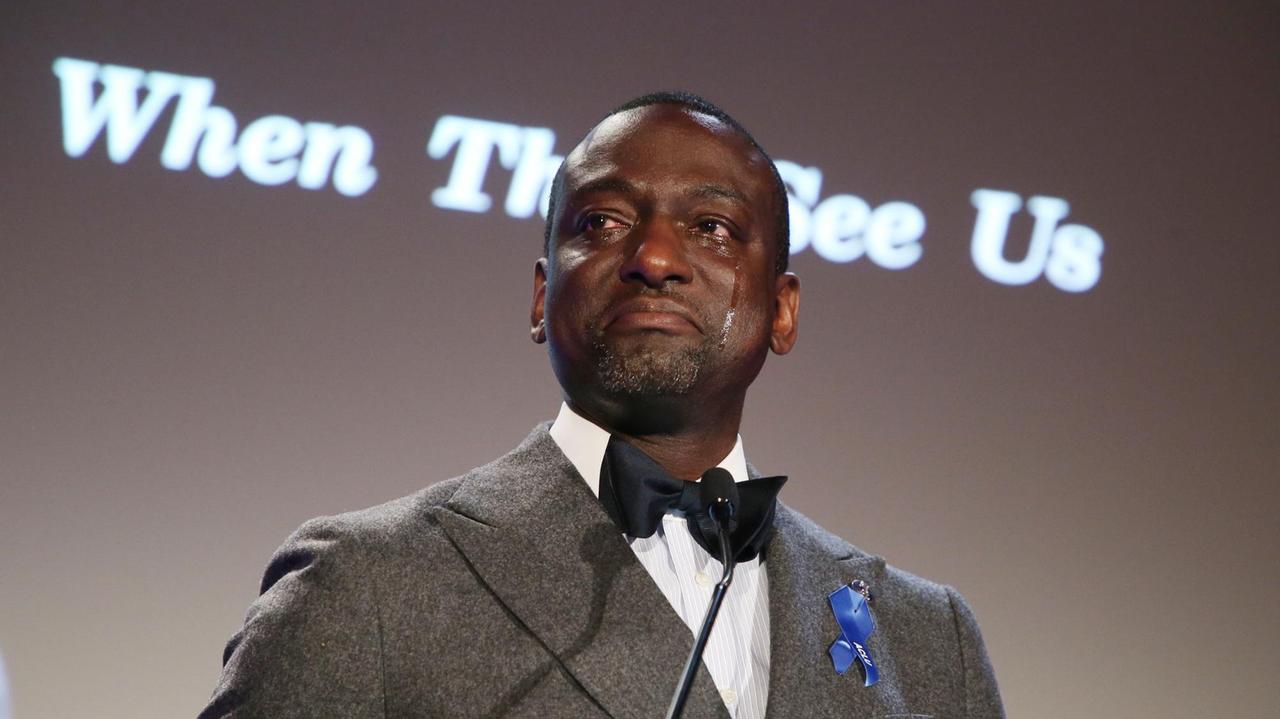 Yusef Salaam weint. Im Hintergrund ist der Titel der Netflix-Serie "When they see us" auf eine Wand projeziert. Diese erzählt die Geschichte vom Yusef Saalm und vier anderer Jugendliche, die zu Unrecht im Gefängnis landeten. Yusef Salaam weint. Im Hintergrund ist der Titel der Netflix-Serie "When they see us" auf eine Wand projeziert. Diese erzählt die Geschichte vom Yusef Saalm und vier anderer Jugendliche, die zu Unrecht im Gefängnis landeten.