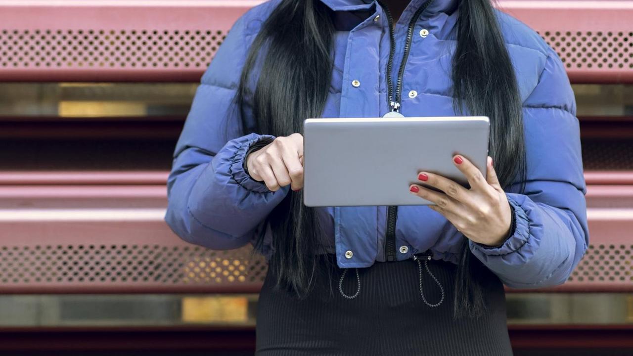 Eine Frau wischt mit dem Finger über ein Tablet Eine Frau wischt mit dem Finger über ein Tablet