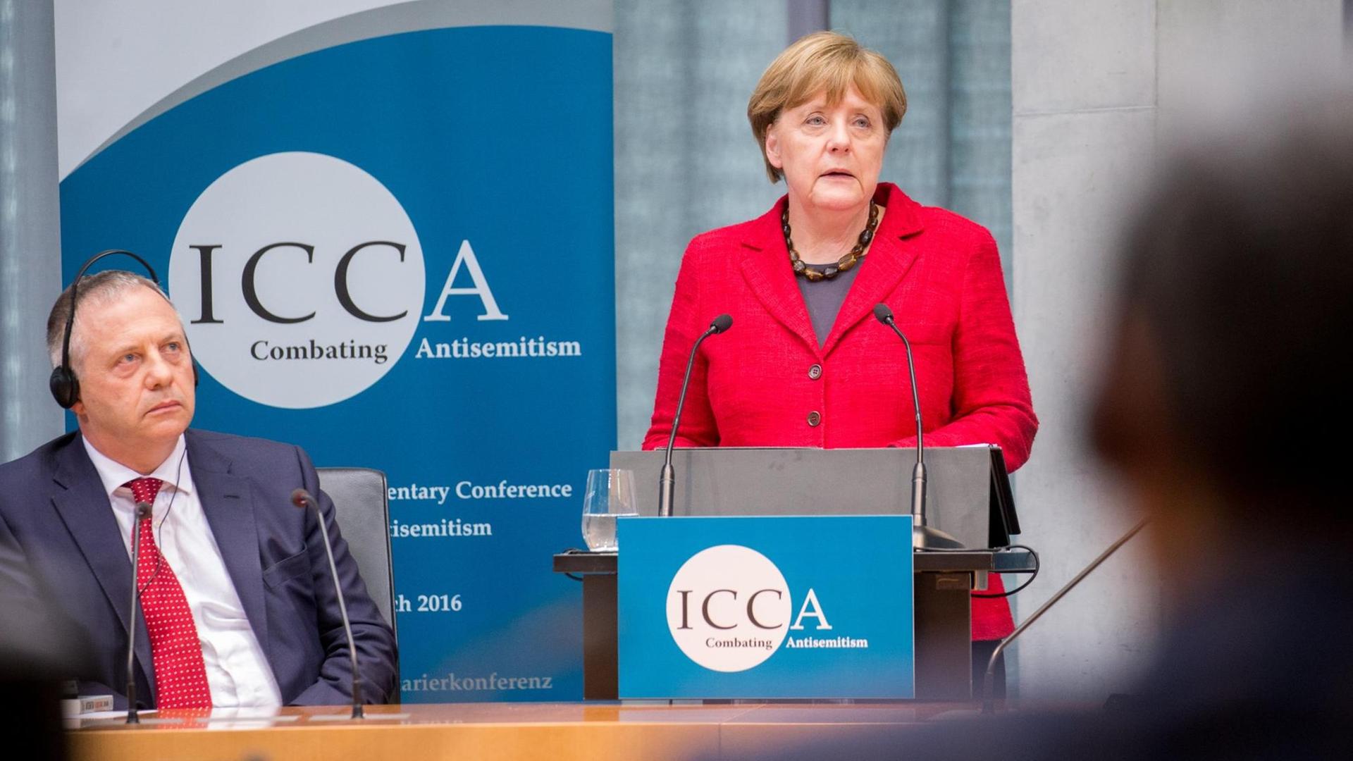 Bundeskanzlerin Angela Merkel (CDU) spricht am 14.03.2016 bei der ICCA Antisemitismus Konferenz in Berlin neben dem Vorsitzenden der ICCA, John Mann. Bundeskanzlerin Angela Merkel (CDU) spricht am 14.03.2016 bei der ICCA Antisemitismus Konferenz in Berlin neben dem Vorsitzenden der ICCA, John Mann.